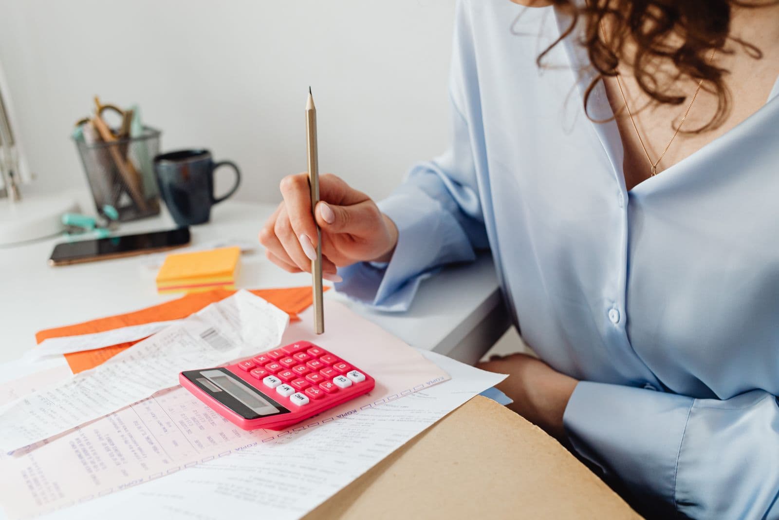 Calculator and paperwork being used to compare expenses