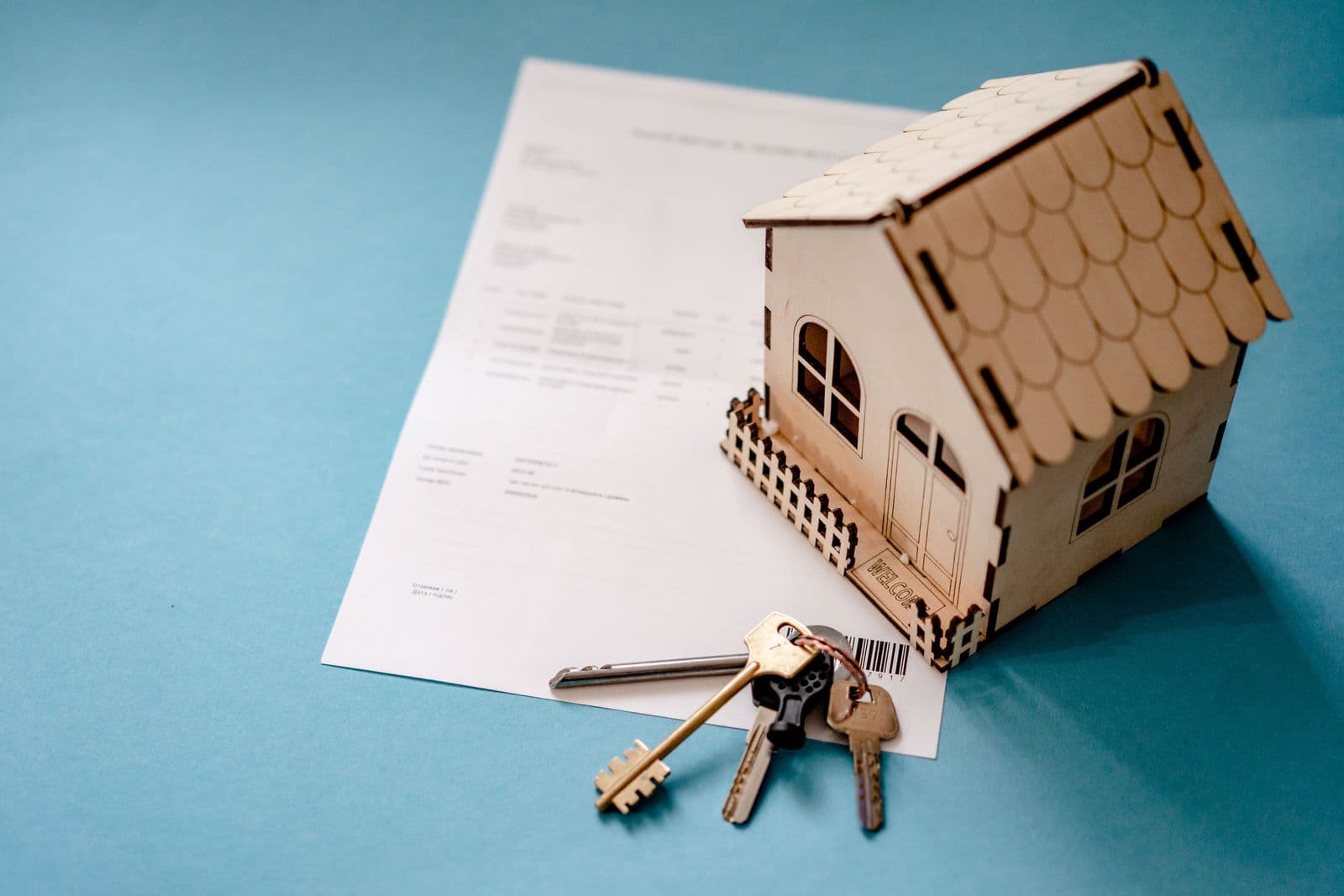House model and keys beside a purchase agreement