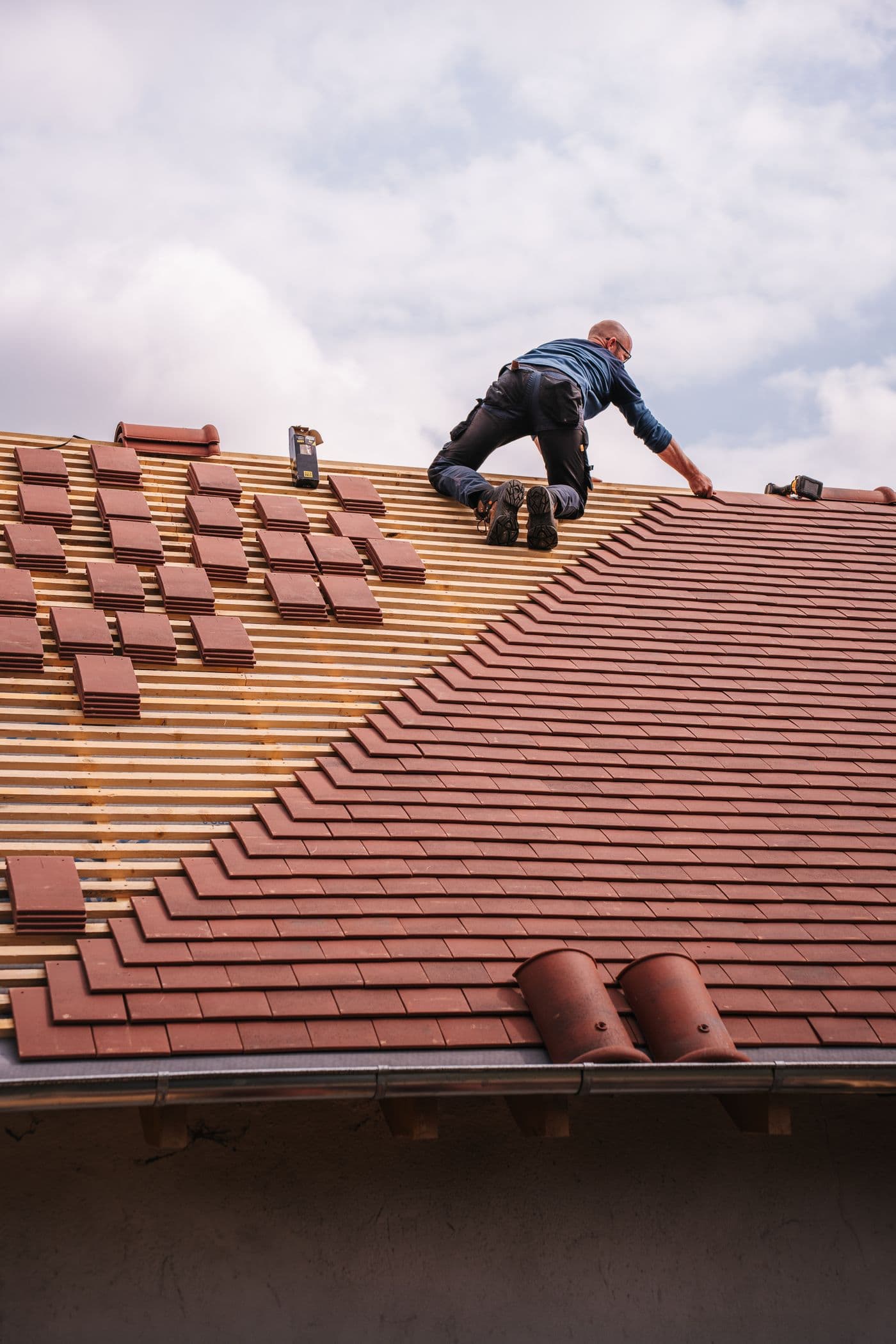 Roofer installing tiles on a residential roof