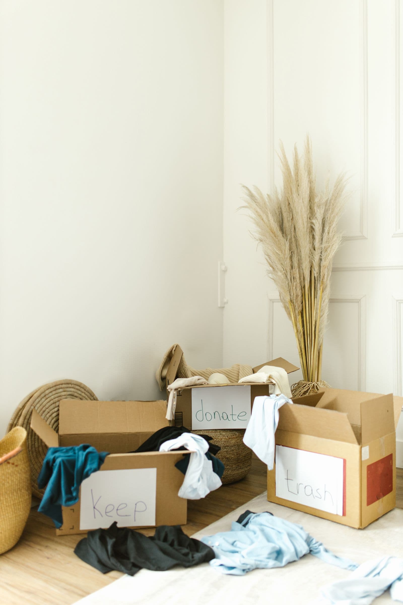 Belongings being sorted into keep, donate and trash boxes