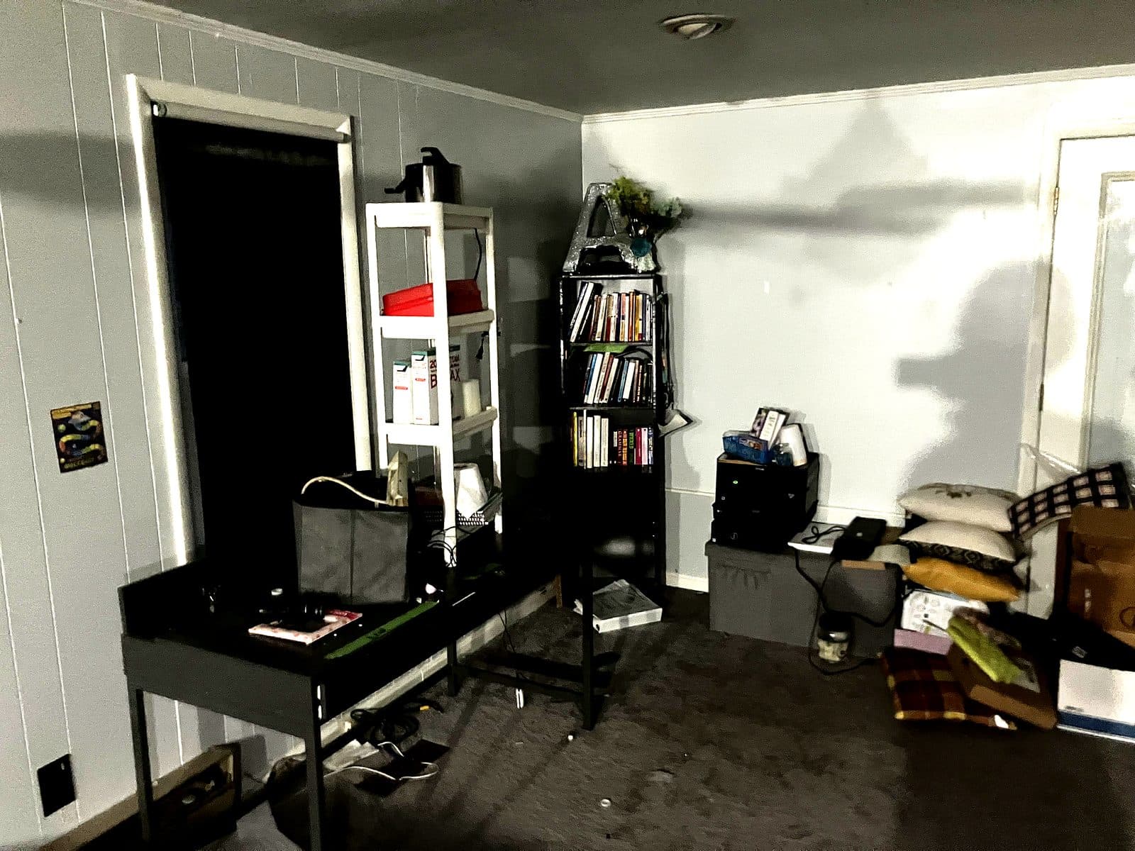 Occupied room with a desk, bookshelves and household belongings still in place