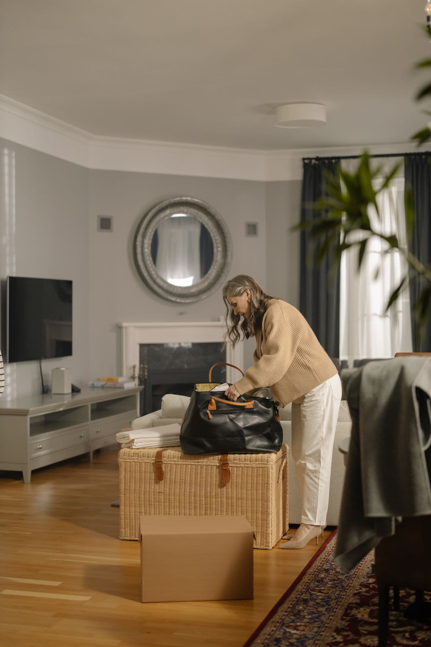 Older woman packing a bag in her living room