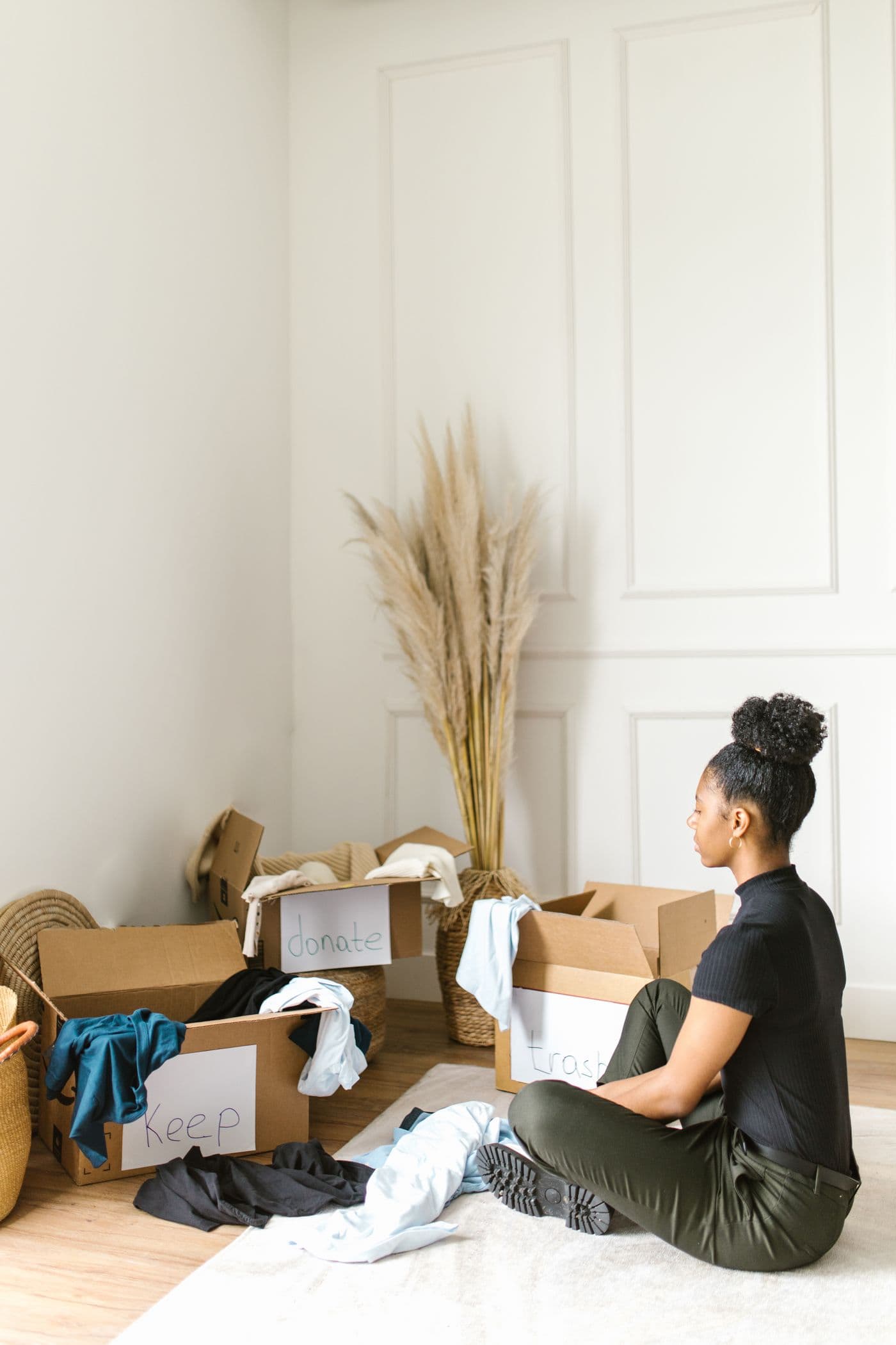 Woman sorting clothing into boxes at home