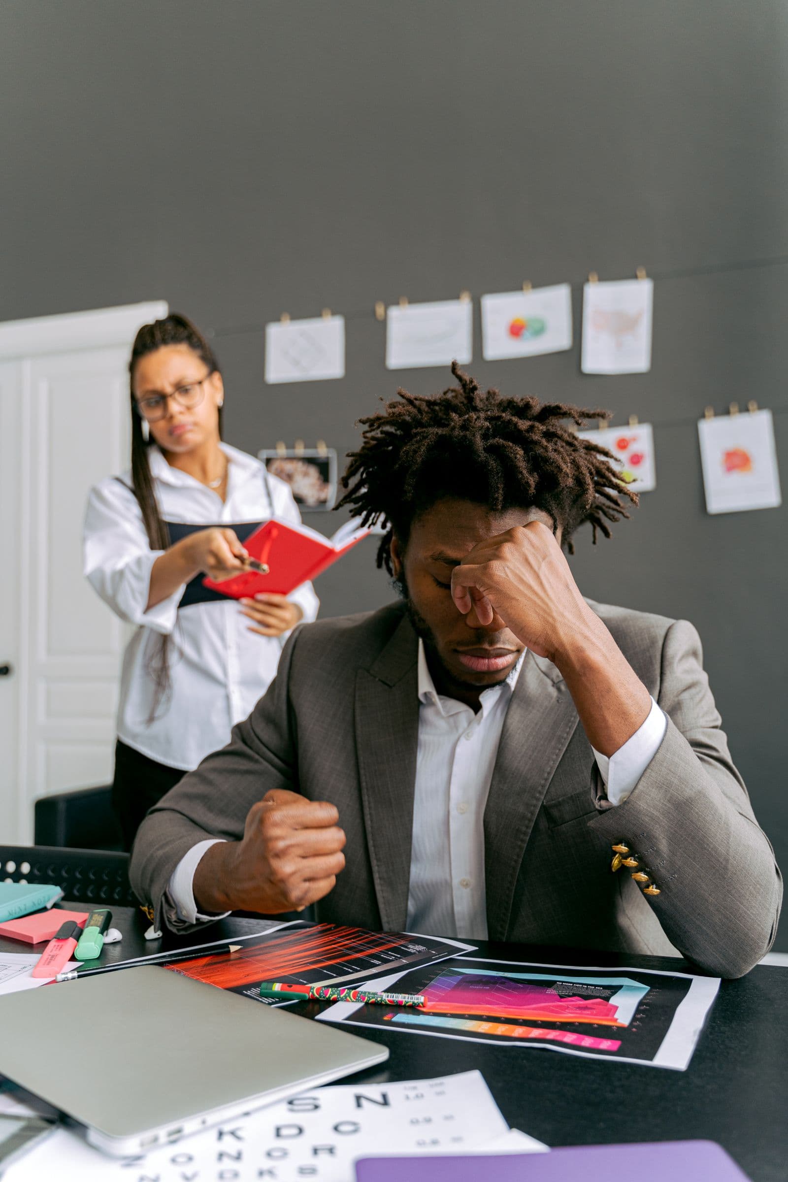 Man resting his head in his hand beside a folder of documents