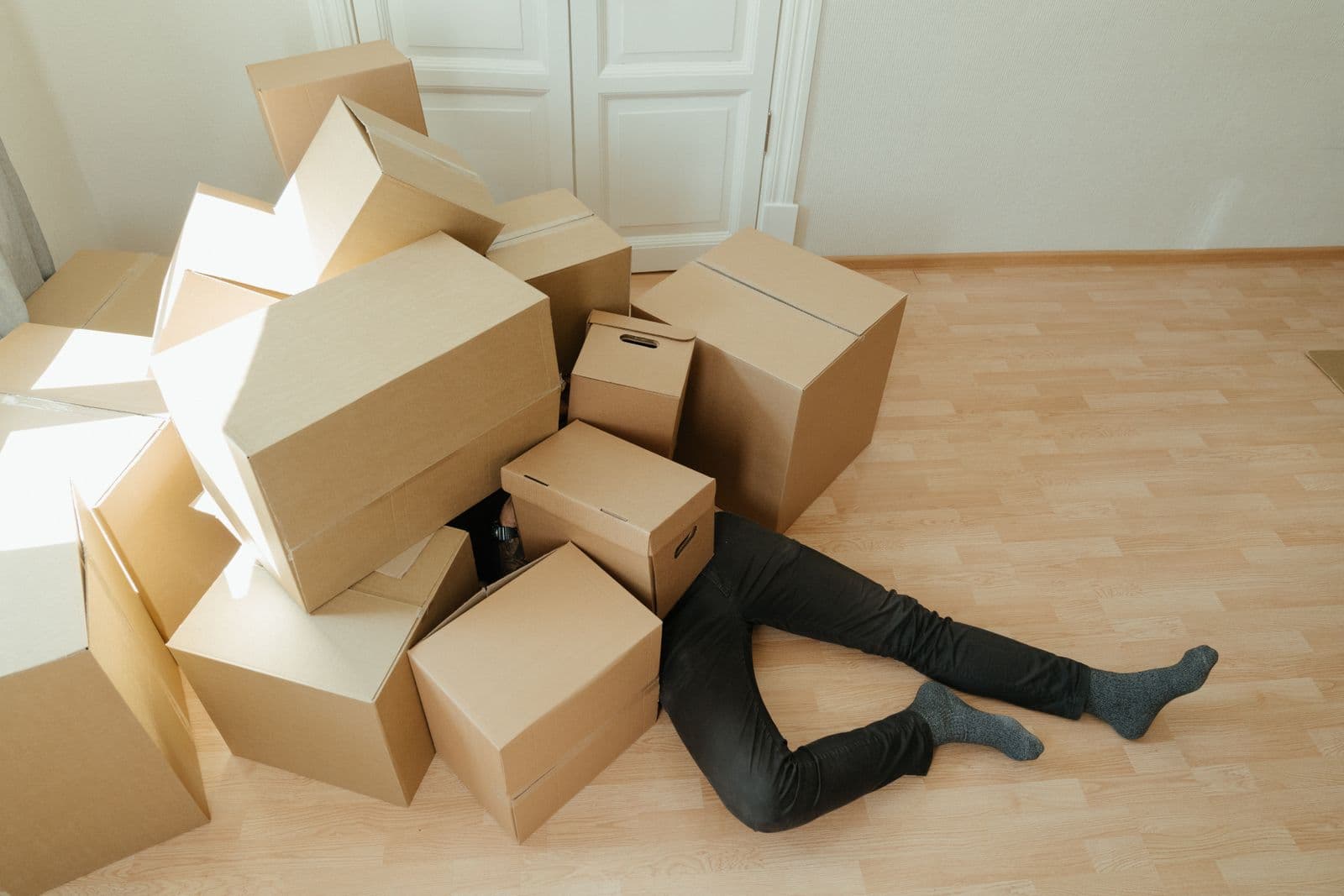 A person surrounded by a pile of moving boxes