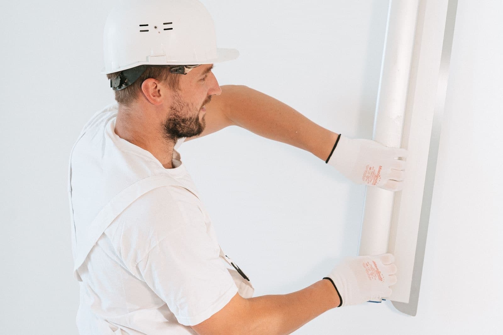 Worker in a hard hat smoothing a freshly repaired wall